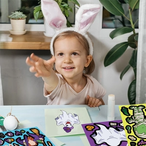 Παιδί παίζει με αυτοκόλλητα Halloween για δημιουργία προσώπων φαντασμάτων και μαγισσών