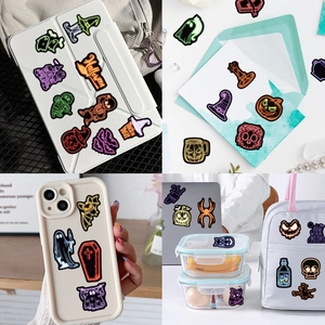 Neon Halloween stickers showing applications on tablets, phone cases and laptop covers
