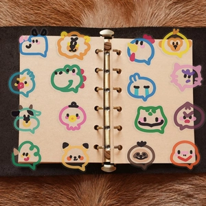 Macro detail of 16 cute animal bubble stickers on vintage notebook paper with plush background