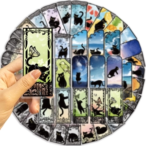 Detailed view of hand holding a black cat art sticker with baroque floral borders