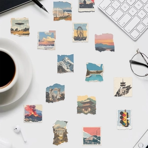 Close-up of vintage torn paper landscape stickers on a white desk with office props
