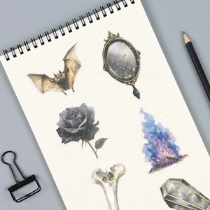 Close-up of vintage magic stickers with gold glitter on a white spiral notebook