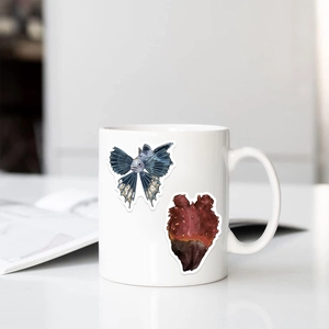 Détail des autocollants de créatures marines sur un mug en céramique blanche avec poissons