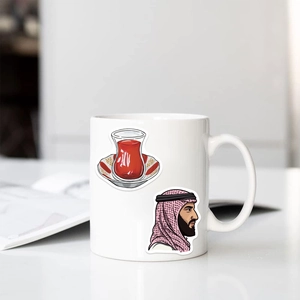 Detail of white ceramic mug featuring Middle Eastern art stickers and ergonomic handle