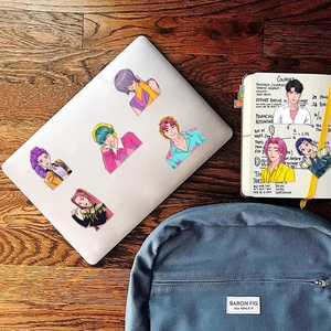 Autocollants anime DIY sur un ordinateur portable argenté et un carnet de notes
