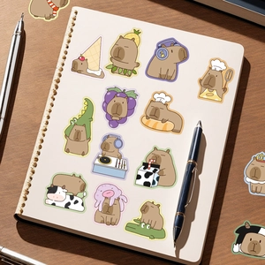 Detailed view of cute Capybara cartoon stickers on a white spiral notebook with pens