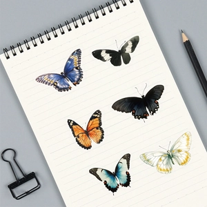 Flat lay of elegant butterfly stickers on a lined notebook with aesthetic stationery tools