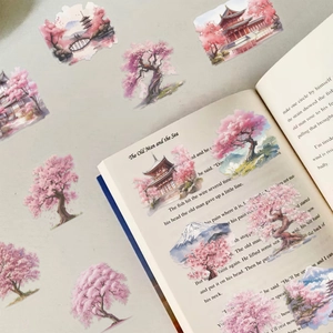 Transparent watercolor Japanese stickers with cherry blossoms and Mt. Fuji on an open book