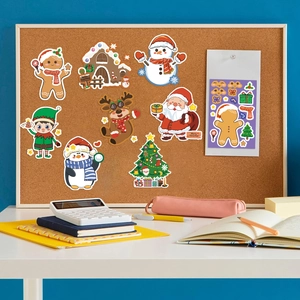 Close-up of Christmas stickers featuring gingerbread men and reindeer on a cork board setup