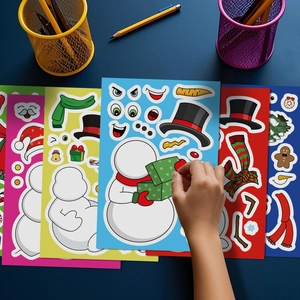 Gros plan de mains appliquant des autocollants de bonhomme de neige de Noël pour activités créatives