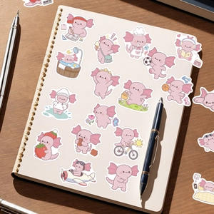 Close-up of cute pink axolotl stickers on a white notebook over a cozy wooden desk