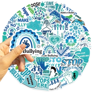 Close-up showing a hand holding a Stop Bullying sticker with a rainbow and text detail