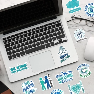 Detail of anti-bullying stickers with inspirational slogans on a laptop and desk