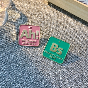 Colorful chemical element enamel pins with Ah and Bs symbols on starry background