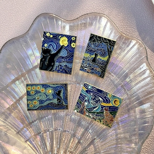 Detailed macro view of Van Gogh style enamel pins featuring cats and starry night patterns