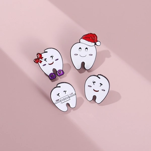 Detailed view of four cute tooth enamel pins with Christmas hats and dental braces