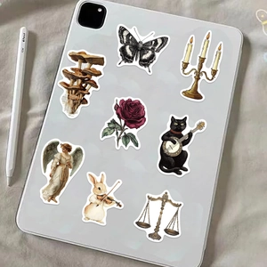 Detalle de pegatinas estéticas vintage con hongos y mariposas en la parte trasera de tablet
