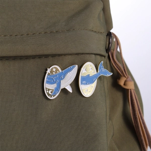 Détail de broches en émail baleine étoilée sur un sac à dos en toile de couleur vert olive
