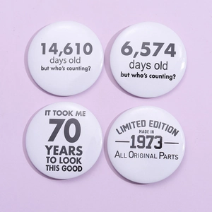 Set of four 70th birthday tin badges with humor years and days counter design