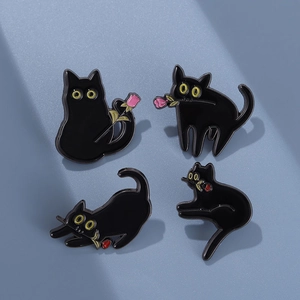 Lot de quatre broches chat noir en émail avec poses variées et détails floraux