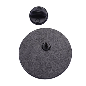 Detail view of round metal badge back with a black rubber clutch and needle pin
