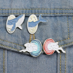 Détail de quatre broches en émail avec baleine et lapin sur une poche de veste en jean