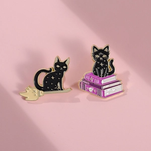 Detail of magic book and broom black cat enamel pins for Halloween costume accessories