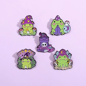 Lot de 5 pin's en émail grenouille magicienne avec baguettes et grimoires en vert et violet