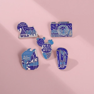 Detailed set of 5 blue enamel pins featuring mountain tent and camera for outdoor explorers