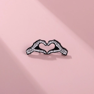Broche gothique en émail mains de squelette formant un cœur, noir et blanc