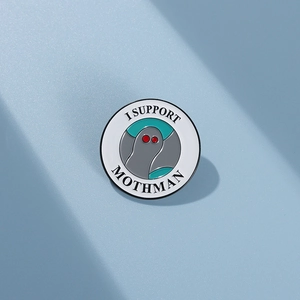 Detailed view of the enamel pin featuring I SUPPORT MOTHMAN text and red eyes