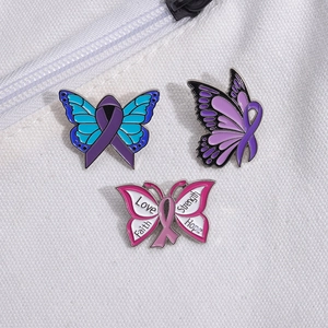 Trois épinglettes papillon en émail coloré avec rubans sur fond de toile blanche
