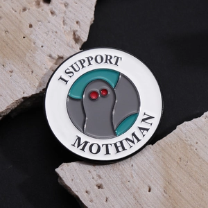 Round Enamel Pin featuring Mothman illustration with text I SUPPORT MOTHMAN on stone