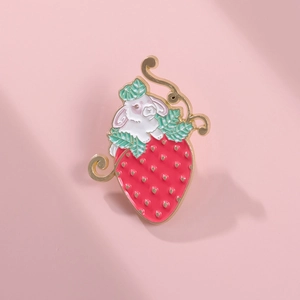 Close-up of cute white rabbit in strawberry enamel brooch with gold metallic detailing
