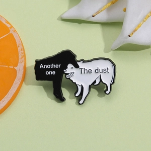 Close-up of enamel pin set with funny black and white dogs and another one bites the dust text