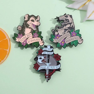 Detailed view of three funny opossum enamel pins with colorful floral accents