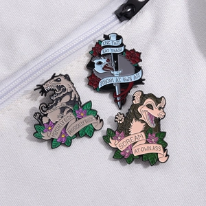 Three-piece opossum enamel pin set with retro ribbons and roses on fabric background