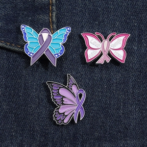 Vue détaillée de trois broches papillon en émail avec rubans sur fond en denim bleu