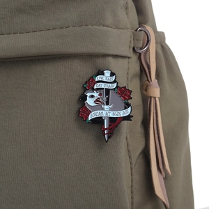 Detail of possum enamel pin with Live Fast slogan on a green canvas backpack