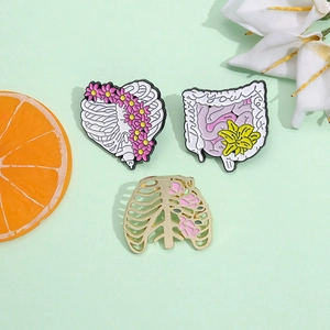 Creative anatomical organ enamel pins featuring floral ribs and trust your gut intestine design