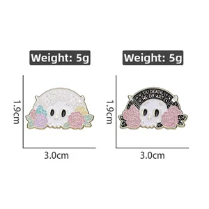 Detail view of floral skull enamel pins with 'TIL DEATH WE DO ART' text and dimensions