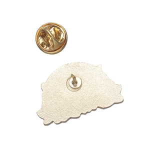 Macro shot of light gold metal brooch backing with clutch pin and butterfly clasp closure