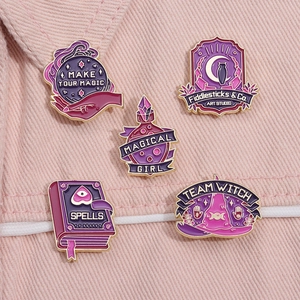 Close-up of five purple witch enamel pins featuring crystal ball and magic spell book