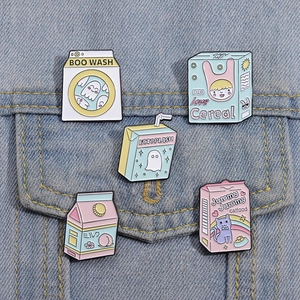 Detail of five cute enamel milk carton and snack pins pinned on a blue denim jacket pocket