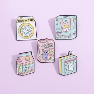 Macro detail of five macaron-colored enamel pins featuring cute milk box and cereal designs