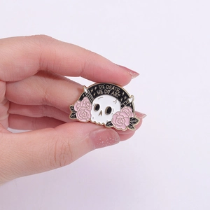 Detail of gothic enamel pin featuring a skull and rose with Til Death We Do Art text