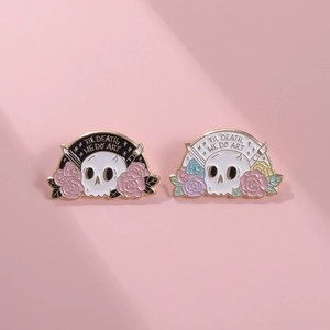 Punk skeleton enamel pins with Til Death We Do Art text and roses on pink background