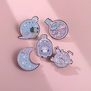 Detail view of five cute pink enamel pins featuring rabbits, moon bottles, and starry planets