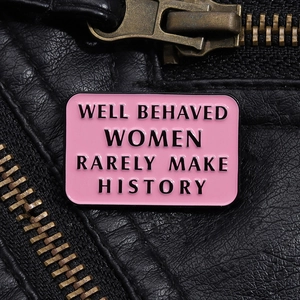 Pink enamel pin with quote Well Behaved Women Rarely Make History on black leather jacket