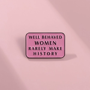 Pink enamel badge detail with Well Behaved Women Rarely Make History text